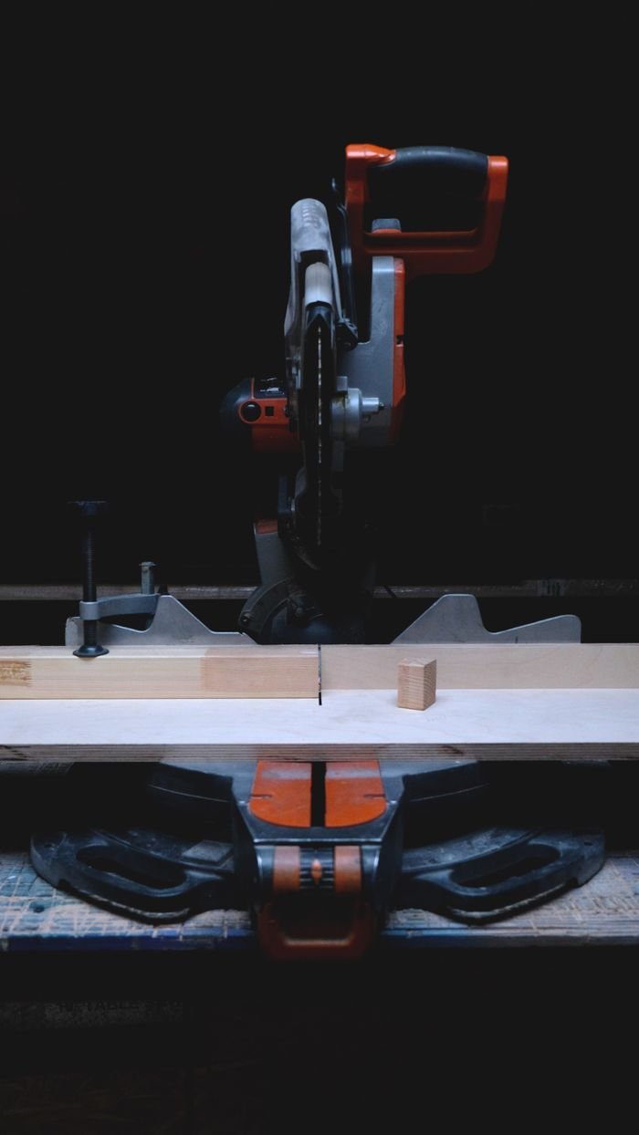 A circular saw in a workshop cuts wood with precision. Ideal for carpentry themes.
