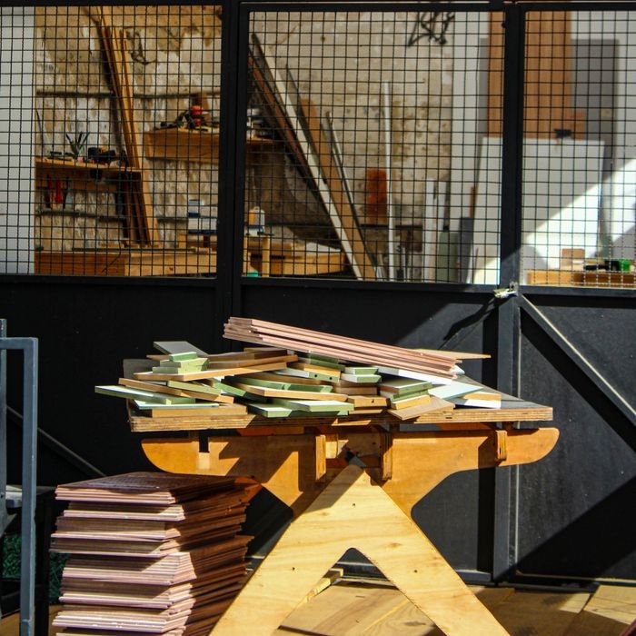 Wooden workbench with stacked materials in a woodworking shop.
